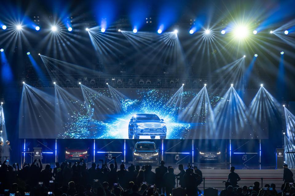 a car is displayed on a large screen at a car show