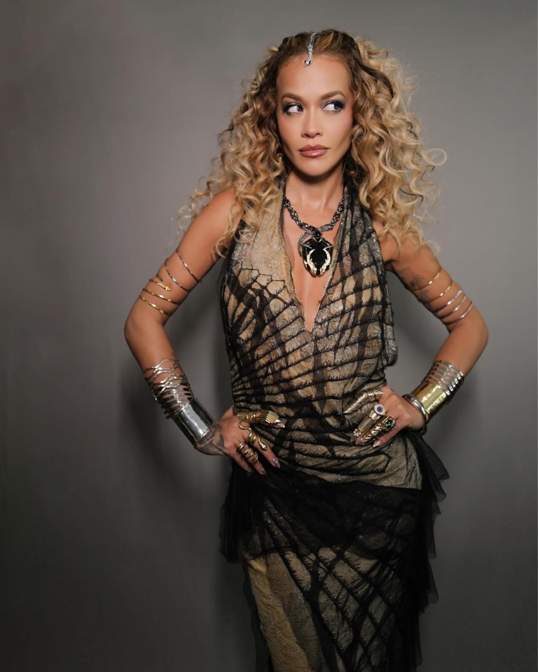 a woman with curly hair wearing a necklace and bracelets