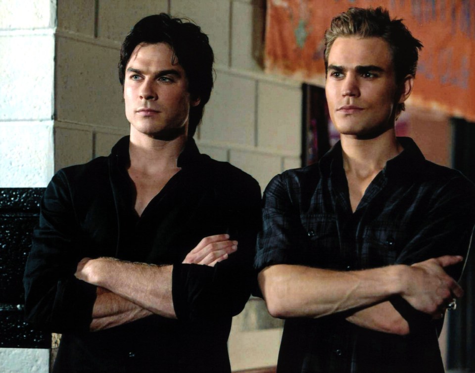 two men standing next to each other with their arms crossed
