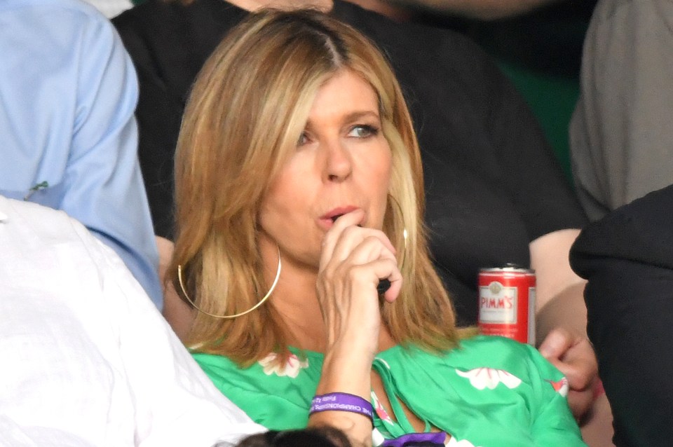 a woman sitting in a crowd with a can of tommy 's beer
