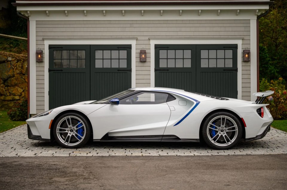 a white sports car is parked in front of a garage