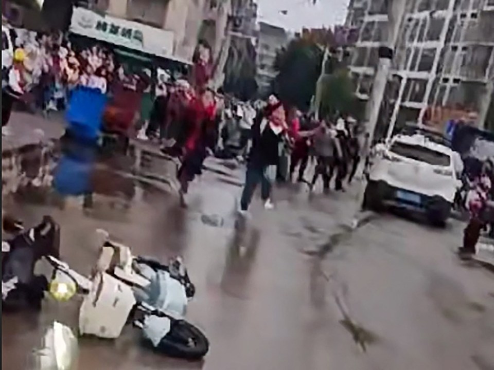 a motorcycle is laying on the ground in the middle of a street .
