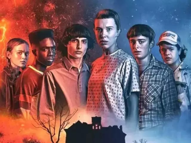 a group of young people standing next to each other in front of a haunted house .