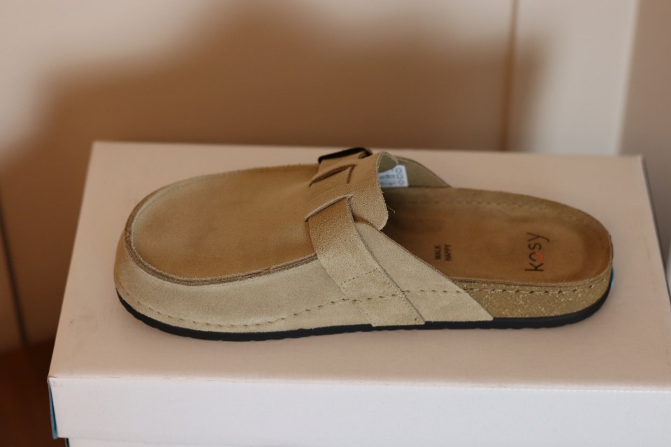 a pair of kosy shoes sits on a white box