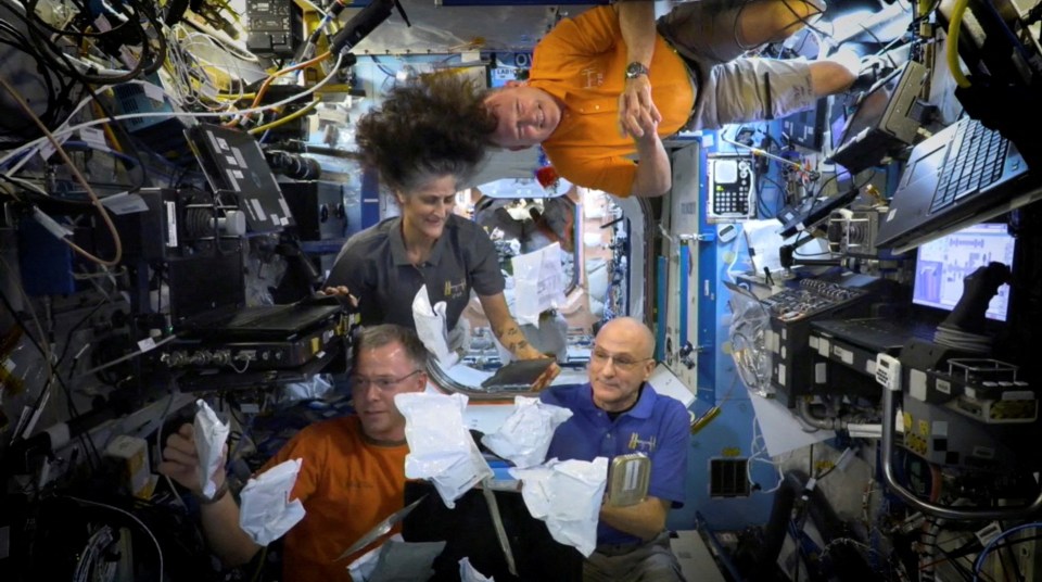 Four astronauts aboard the International Space Station open Thanksgiving meals.