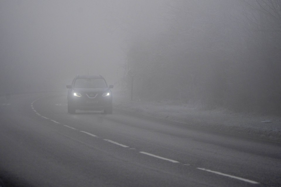 Car driving on a foggy road.