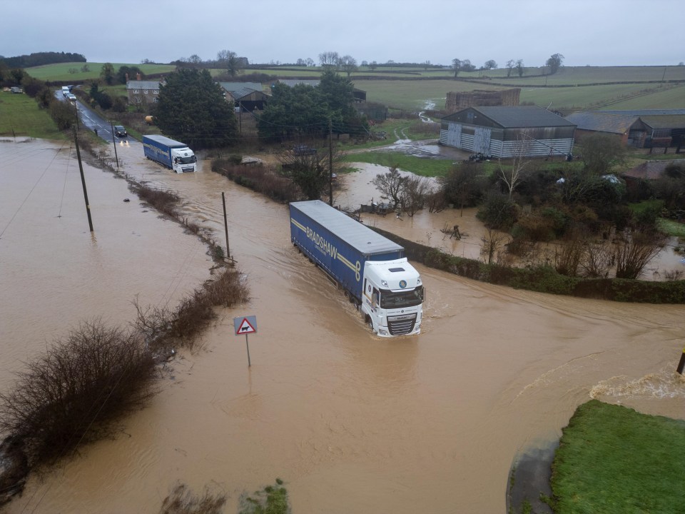 Flooded road with trucks navigating the high water.
