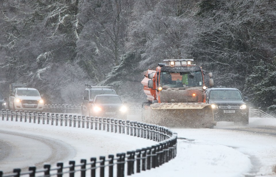 Snow plow clearing a snow-covered road.