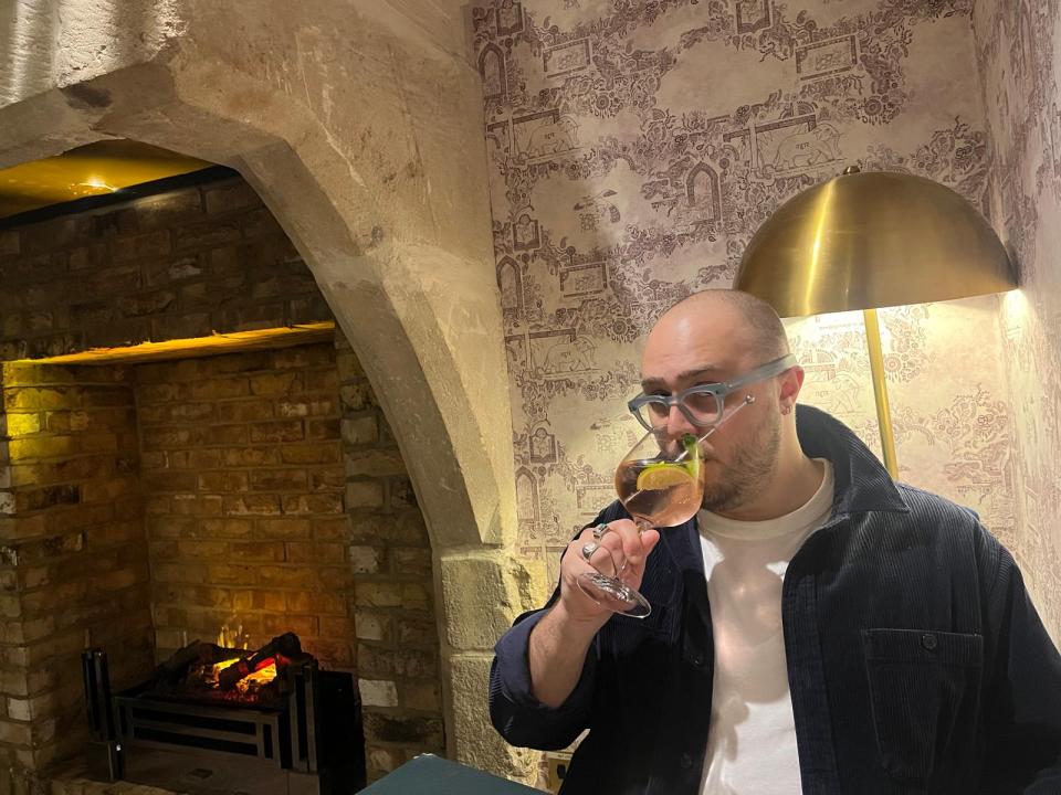 Man drinking a cocktail in a bar.