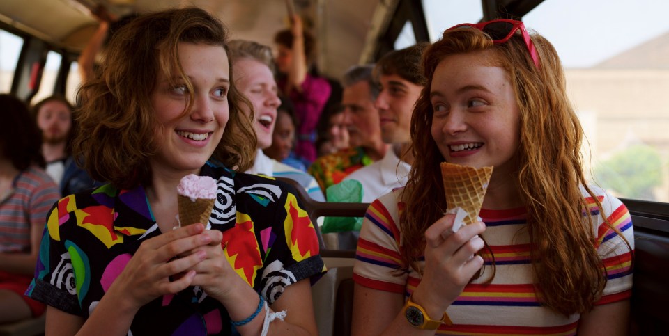 Eleven and Max from Stranger Things eating ice cream on a bus.