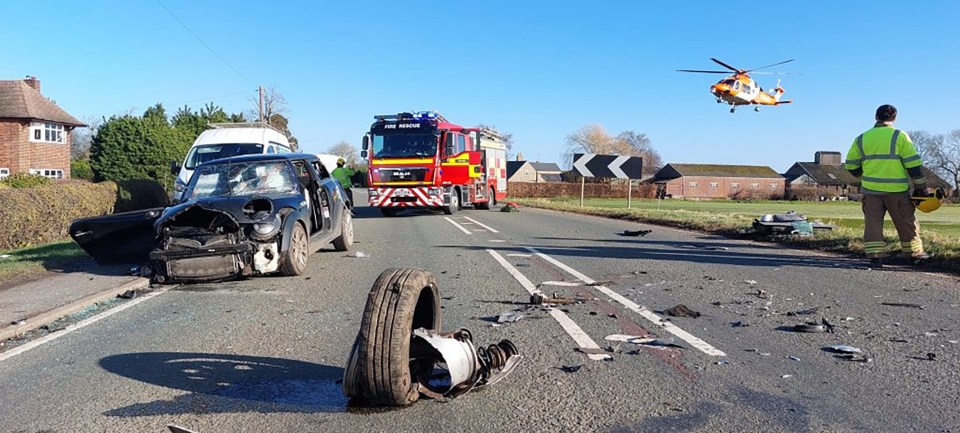Three damaged vehicles at the scene of a car accident, with emergency responders present.