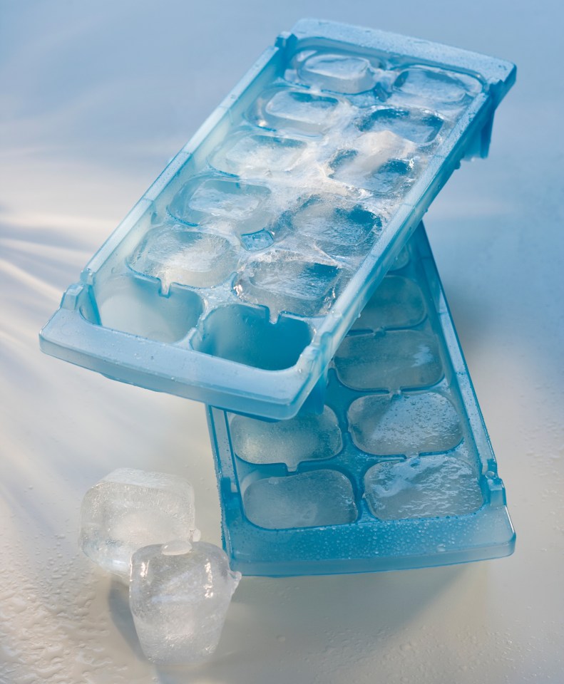 Two blue ice cube trays with ice cubes.