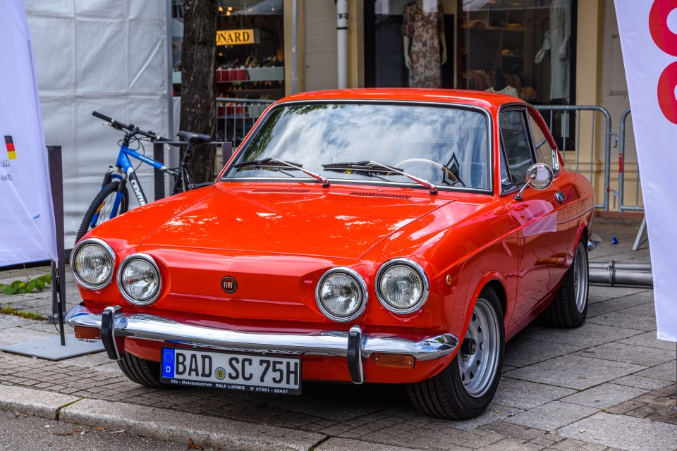 Red Fiat 850 Sport Coupe parked at a car show.