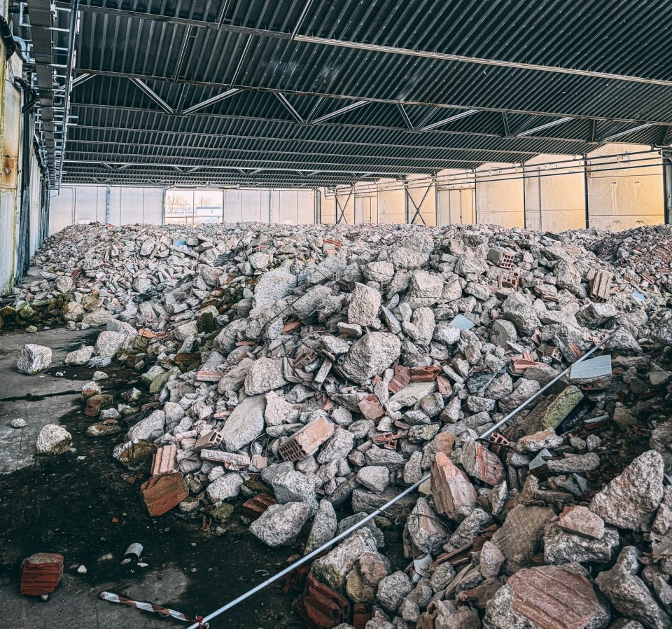 Interior of an abandoned Bugatti factory filled with rubble.