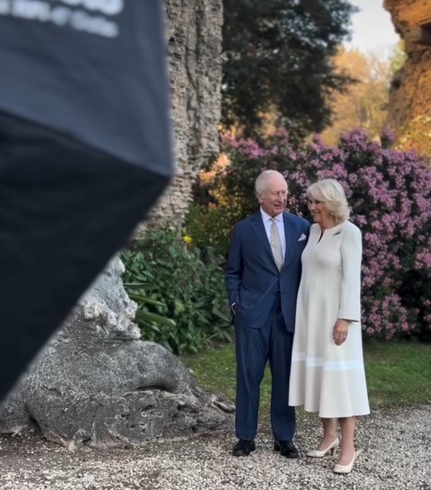 King Charles III and Camilla, Queen Consort, standing in a garden.