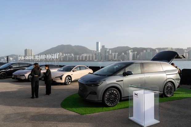 An XPeng X9 electric vehicle and other models are displayed at the company's showcase event in Hong Kong on Tuesday, April 15, 2025. (AP Photo/Chan Long Hei)