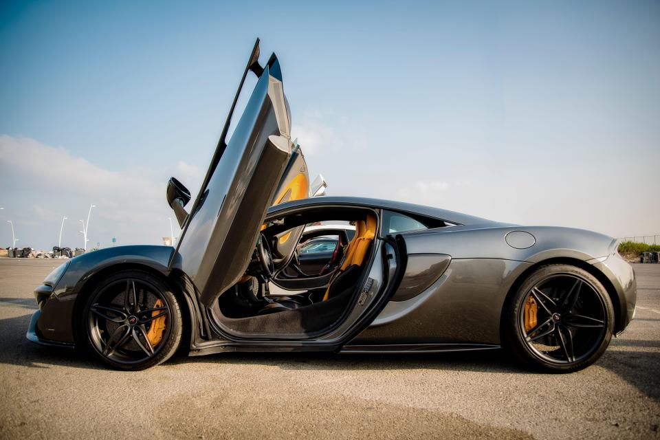 Dark grey McLaren 570S with doors open.