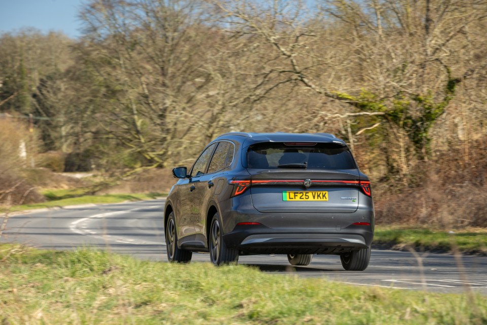 Gray MG5 EV driving on a road.