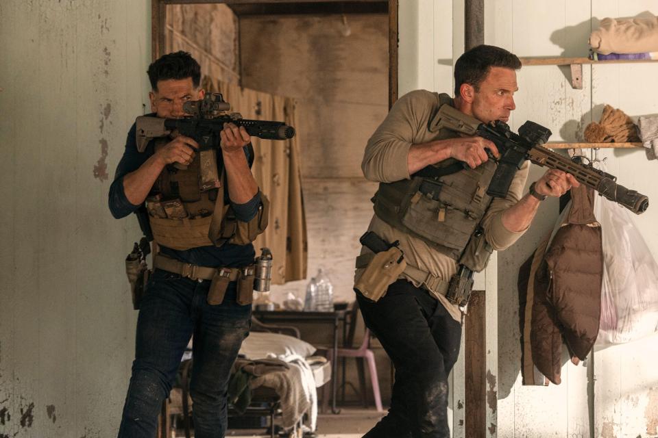 Film still of two armed men in tactical gear.