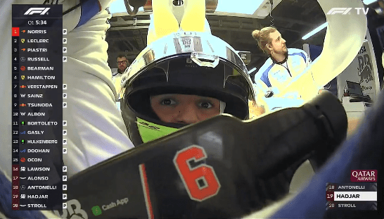 Close-up of a race car driver's helmet and hands, with the number 6 visible.