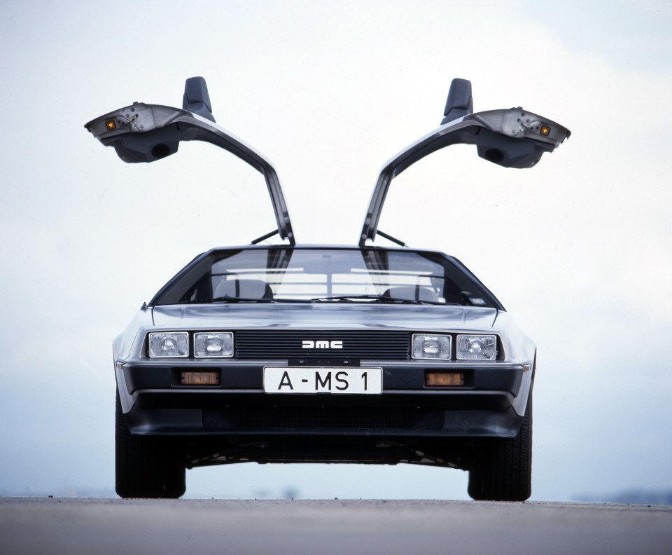 Silver DeLorean DMC-12 with gull-wing doors open.
