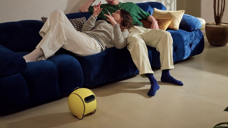 Couple relaxing on a couch with a yellow projector.