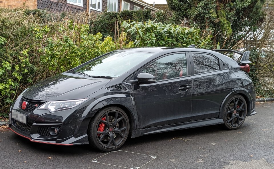 Black Honda Civic parked in a driveway.