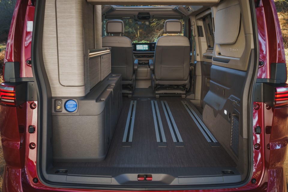Interior of a Volkswagen plug-in hybrid campervan with rear doors open.