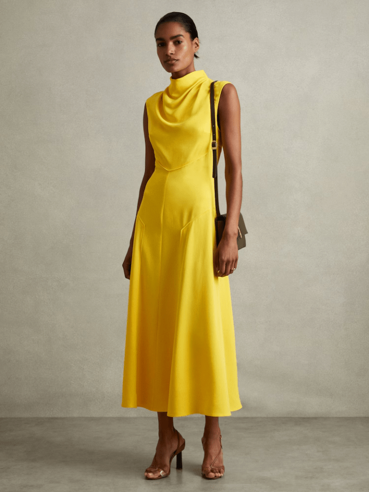 Woman in a yellow midi dress and brown heels.