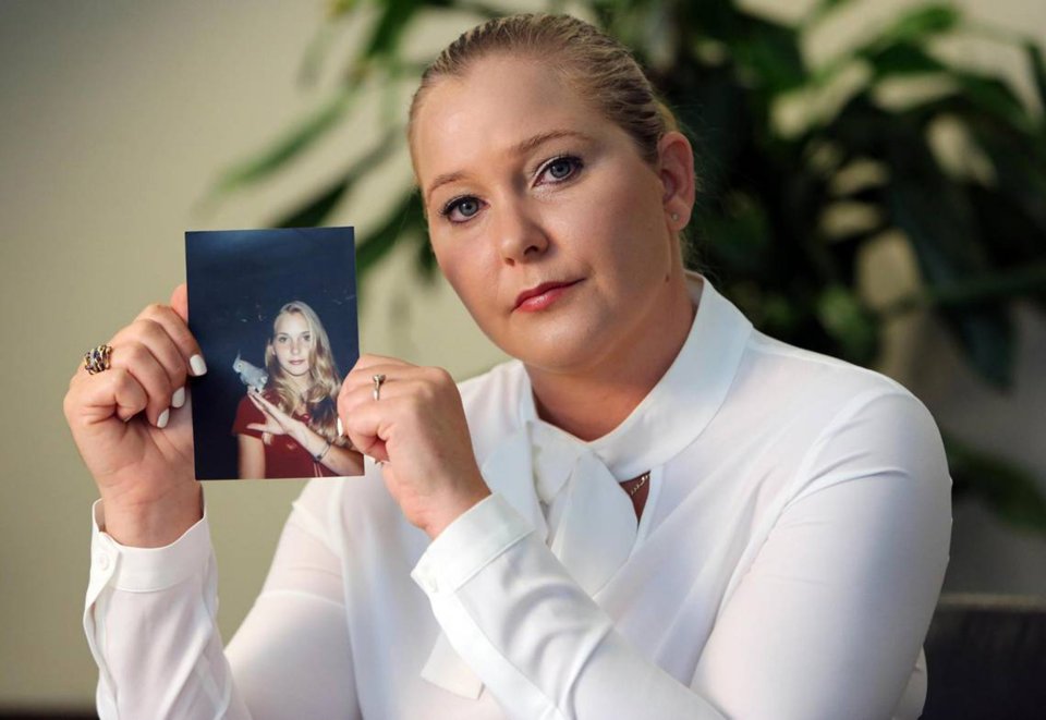 Woman holding a photo of a younger woman.