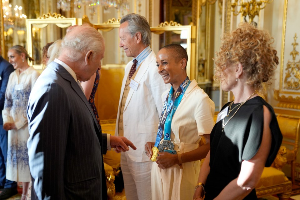 King Charles III speaking with Adele Roberts at a Buckingham Palace reception.