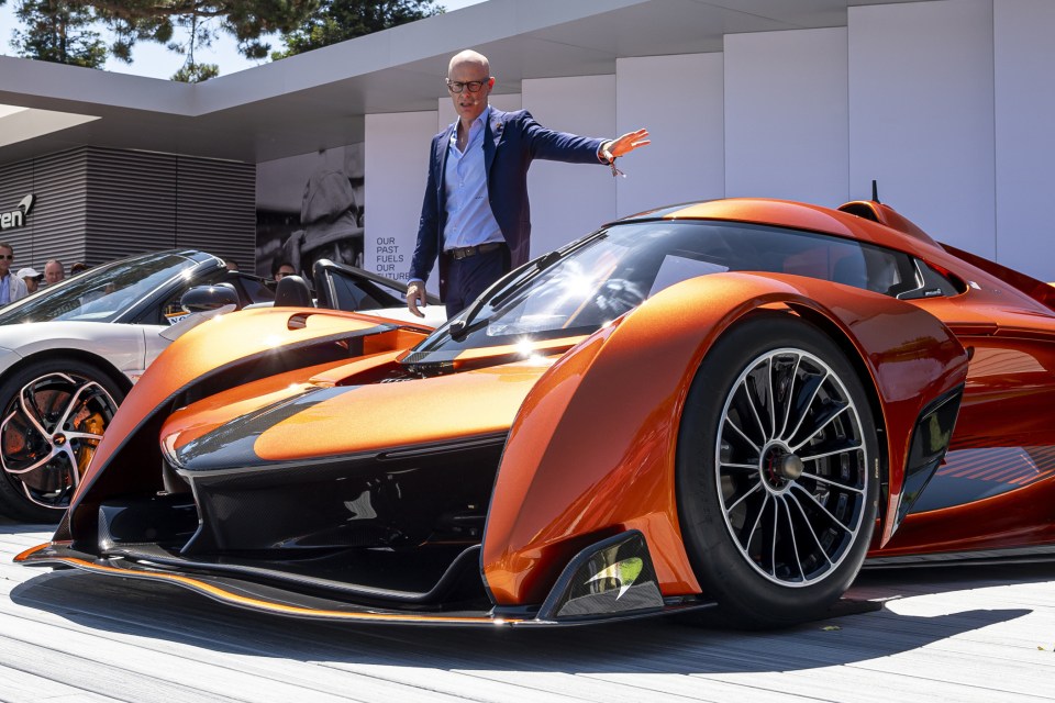 McLaren Automotive CEO Michael Leiters standing next to an orange McLaren Solus GT.