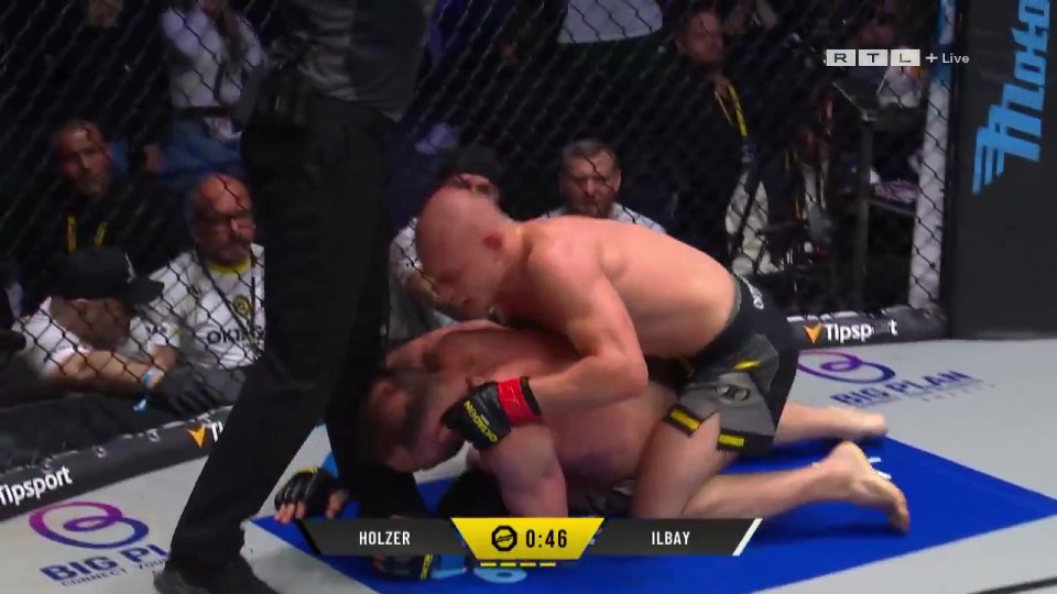 MMA fighter Holzer on top of Ilbay in the octagon.