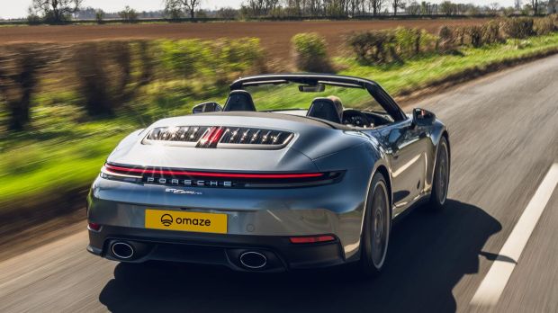 Gray Porsche 911 Carrera S Cabriolet driving on a road.
