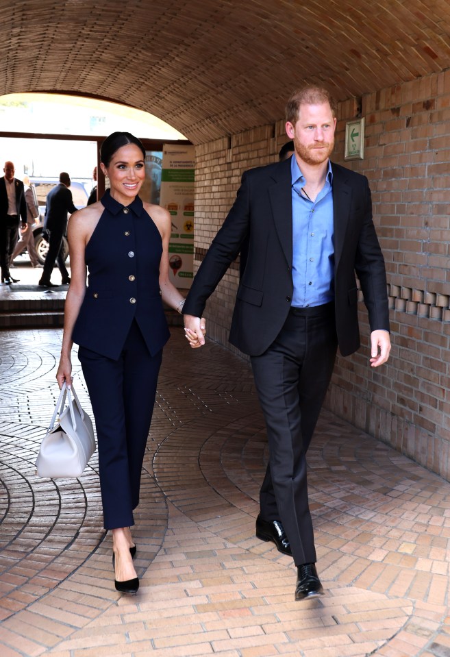 Prince Harry and Meghan Markle walking hand-in-hand.