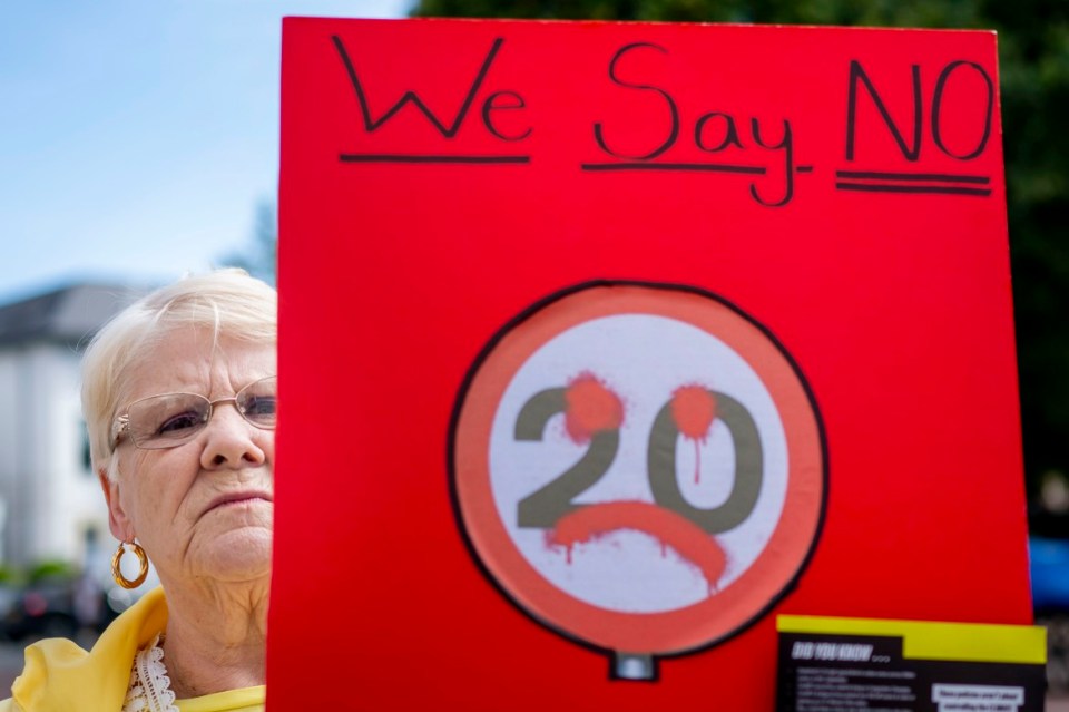 CARDIFF, WALES - SEPTEMBER 23:  A woman holds a sign during a protest against 20mph speed limits on September 23, 2023 in Cardiff, Wales. A default 20mph speed limit has been introduced on restricted roads across Wales. As of September 23, 402,000 people had signed a protest opposing the move. (Photo by Matthew Horwood/Getty Images)