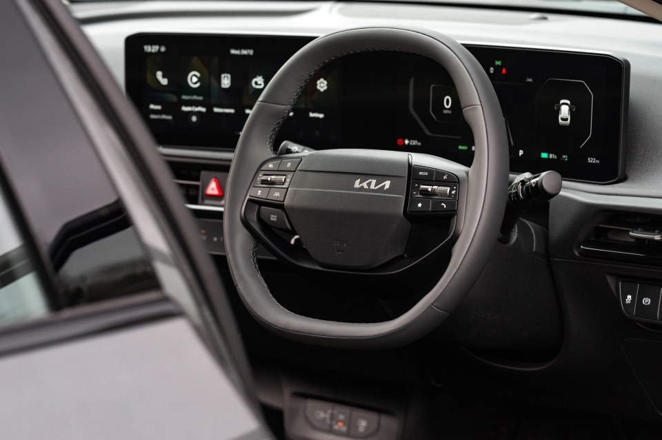 Kia car interior, showing steering wheel and dashboard.