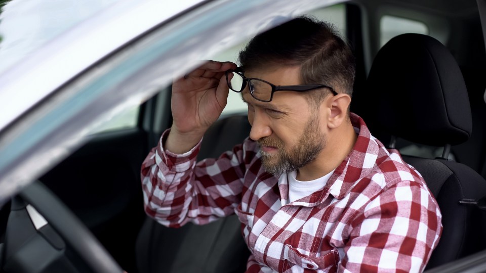 Tired driver removing his glasses.