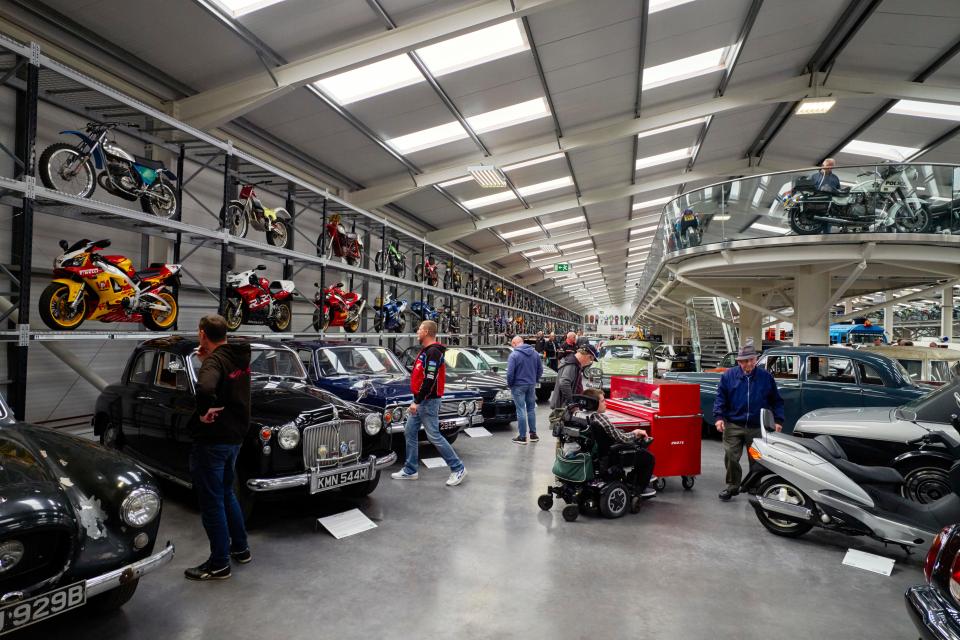 Interior of a motor museum with classic cars and motorcycles, accessible to disabled visitors.