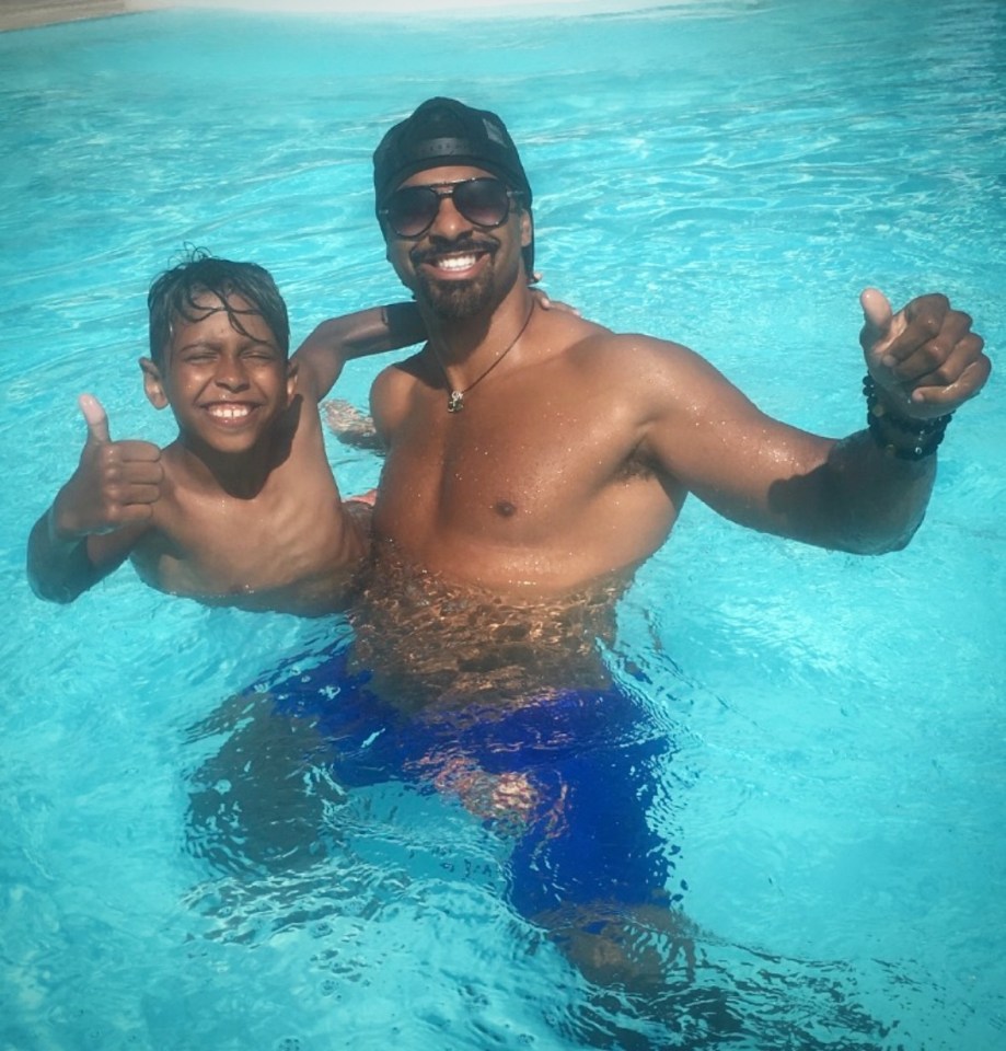Man and boy giving thumbs up in a swimming pool.