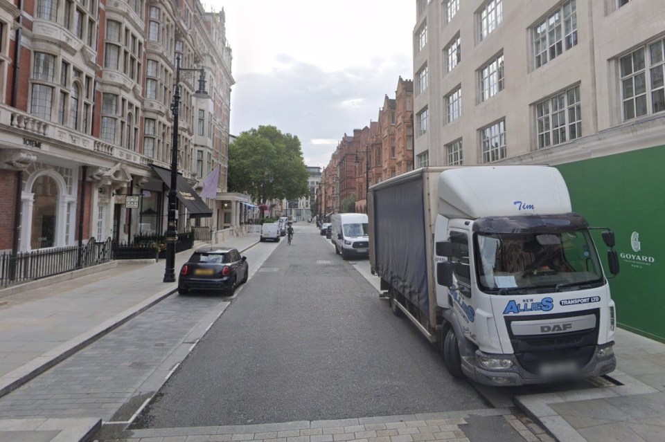 Street scene in London, with parked cars and a delivery truck.