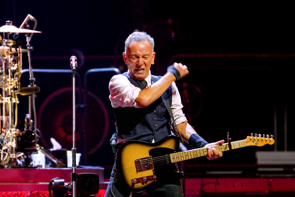 Bruce Springsteen playing guitar on stage.
