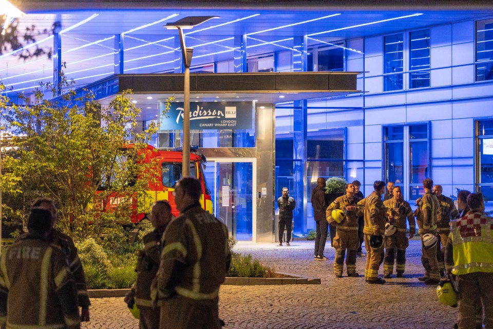 Firefighters outside a Radisson Blu hotel at night.