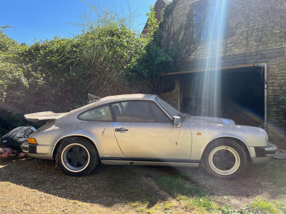 Dusty silver 1989 Porsche 911 Carrera Sport Coupe in a garage.