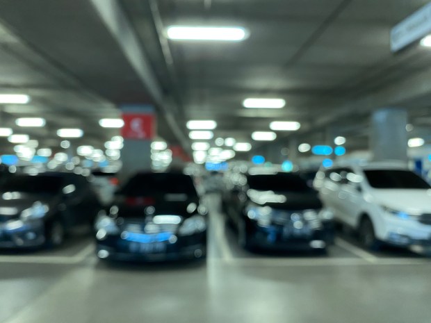 Blurred photo of cars in a parking garage.