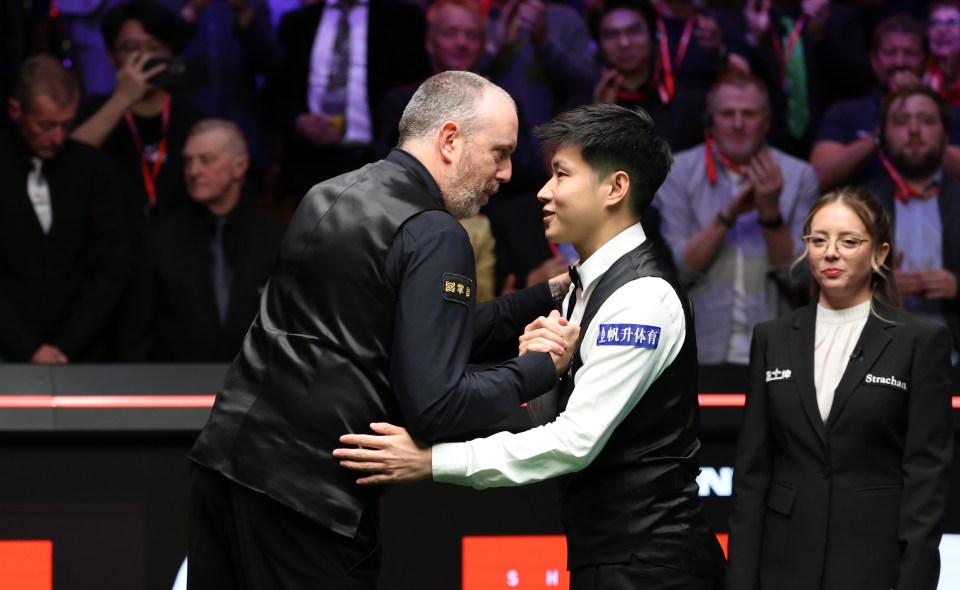 Zhao Xintong of China greets Mark Williams of Wales after a snooker match.