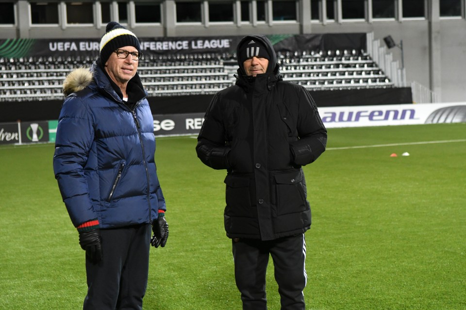 Alan Pardew and Stoycho Mladenov on a soccer field.