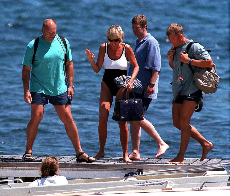 Princess Diana and three men walking on a dock in Saint-Tropez.