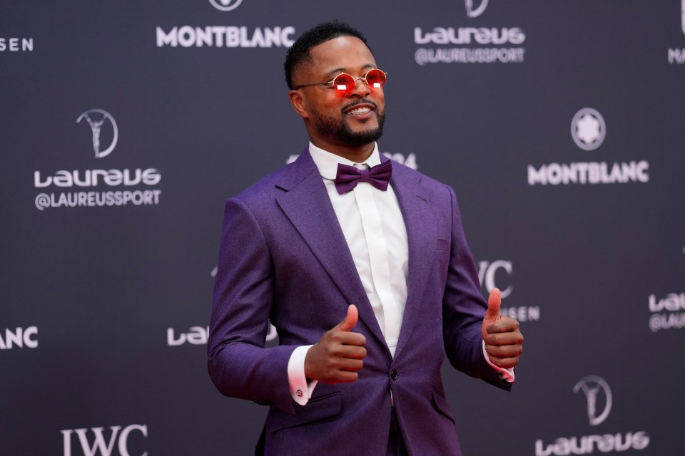 Patrice Evra giving a thumbs-up at an awards ceremony.
