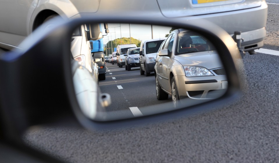 Traffic jam reflected in a car's side mirror.
